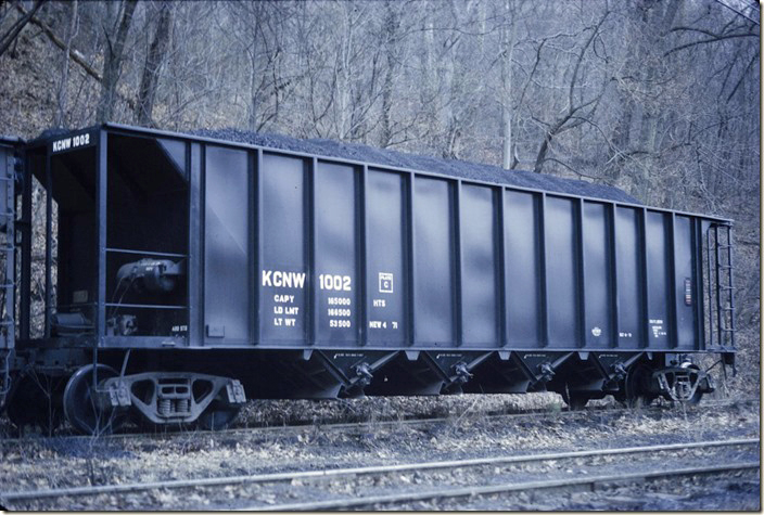 Kelleys Creek & Northwestern 1002 had a load limit of 168,500 and a volume of 2970 cubic feet. It was built by Ortner Freight Car Co. in 1971. In a roller bearing age this car is equipped with plain bearings. Near Cedar Grove WV, on 03-16-1972. From much later dates more cars were acquired, and the series ran up into the 1040s at least.