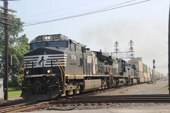 NS 9763, 8434, and 7570 crossing the diamond with a stack train.