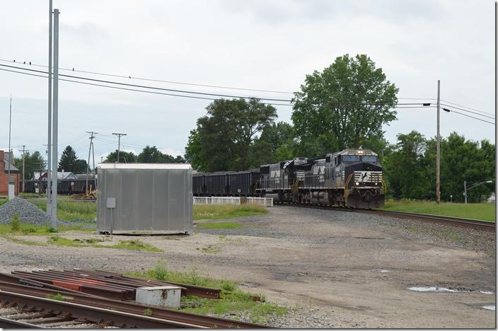 NS 9443-2555 rumble w/b through Bucyrus with 866-20, 104 coke loads from SunCoke Energy at Haverhill OH to Arcelor-Mittal at East Chicago. The restored T&OC station is at the far left. The CFE (former PRR main) crosses behind the aluminum signal house. Pennsy’s tower here was called Colsan. 06-20-2015. Colsan OH.