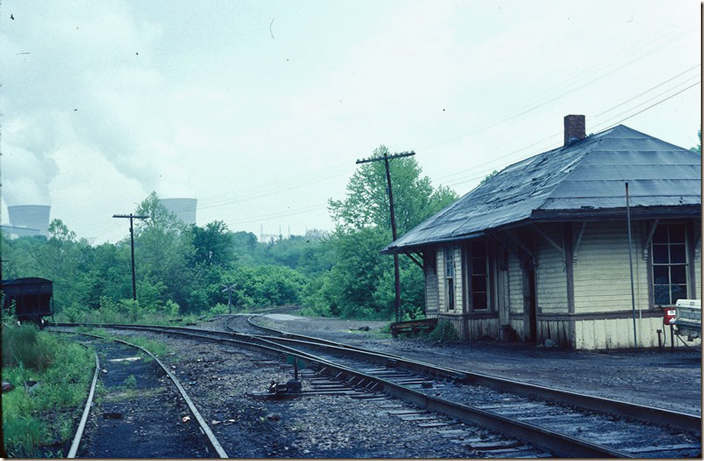 Lumberport depot on 05-23-1980. Looking east on the Short Line SD which is on the right. The connection to the M.R. SD is on the left. Haywood power plant is in the background. Back in the days the heavy coal traffic from Fairmont (sometimes behind EM-1s) would use the connection.