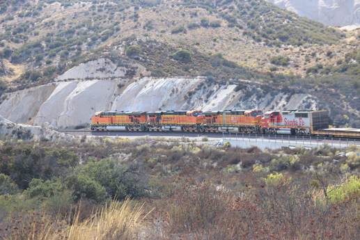 Heading westbound from Summit are BN-SF 7721, a GE ES44DC; BN-SF 7747, a GE ES44DC; BN-SF 7713, a GE ES44DC; and BN-SF 136, a GM GP60M, with a manifest train behind them.