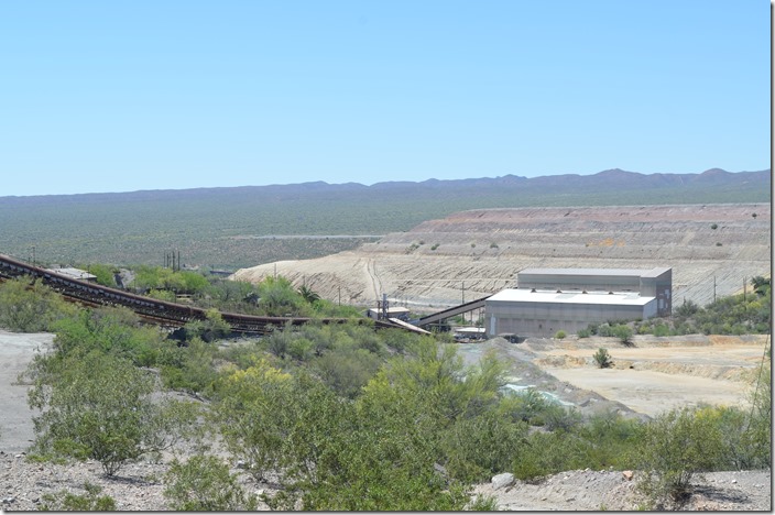 The railroad dumper is down beside the highway. Ore is conveyed up to the crusher (pictured here), and then on up to the plant behind me. In the background are tailings, what is left after the valuable minerals have been removed from the ore. ASARCO crusher. Hayden AZ.