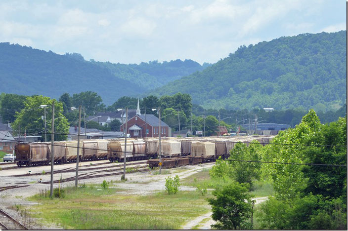 View of north end of the former L&N yard at Ravenna KY. The Eastern Kentucky Subdivision is presumably still inactive between Typo (Hazard) and Patio (Winchester), although I took this photo over a year ago on 06-12-2021. The historically busy yard was being used for covered hopper storage. I was attending the Kentucky Rail Heritage open house to view the progress on restoring former C&O K-4 2716. They use the former CSX blue metal car shop in the distance. CSX yard.