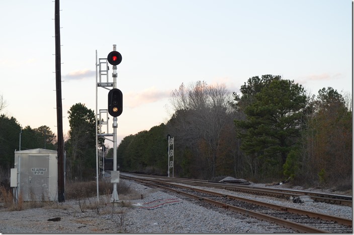 Stop and open switch signal at the north end of Lilesville passing siding. The three track Gravelton Yard is behind me as well as a busy road crossing. The rusted track in the foreground served as the south lead to the yard. I suppose this signal is to remind crews using the yard that the switch ahead onto the passing siding will always be against them. CSX stop & open switch signal NE Lilesville NC.