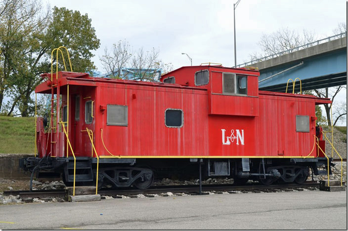 According to the raised letters on the trucks this is an ex-C&O caboose. The highway bridges the Ohio River here to Cannelton IN. Hawesville KY.