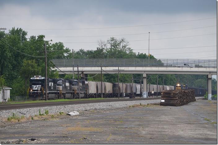 NS westbound 8840 on a grain train overtakes a slower CSX coal train headed by 8567. 08-19-2015. Paved area was part of Marion Power Shovel’s property which was to the right. Marion.