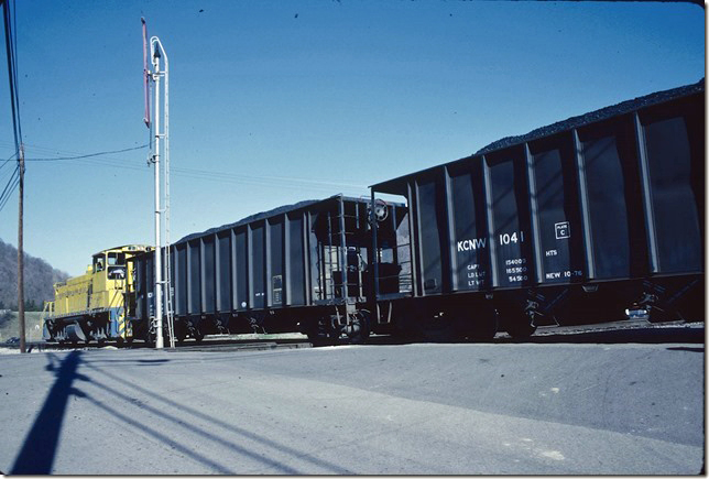 Newer Ortner hoppers. Shoving across Conrail’s West Virginia Secondary at Cedar Grove WV. 1990.