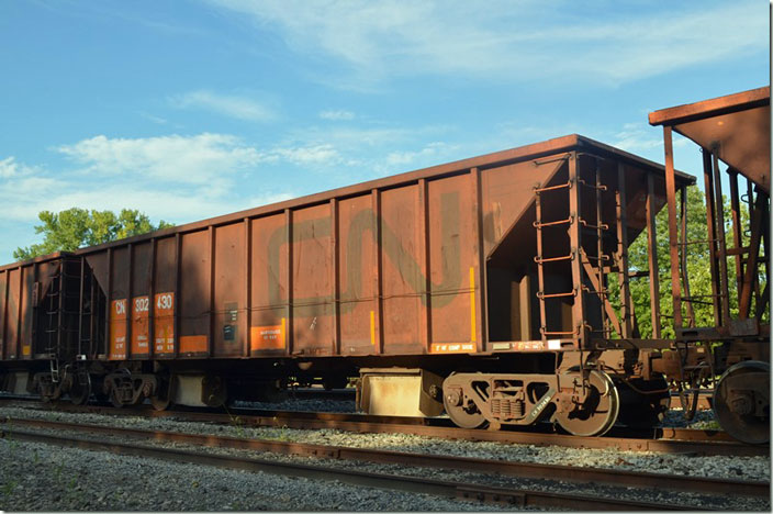 CN MW ballast hopper 302430 on the former Illinois Central at Bluford IL, on 08-29-2021. Built by National Steel Car at their Hamilton, Ontario plant 05-1976. Volume is 2,200 cubic ft. and load limit is 165,000 lbs. It has Dofasco (Dominion Foundry) trucks.