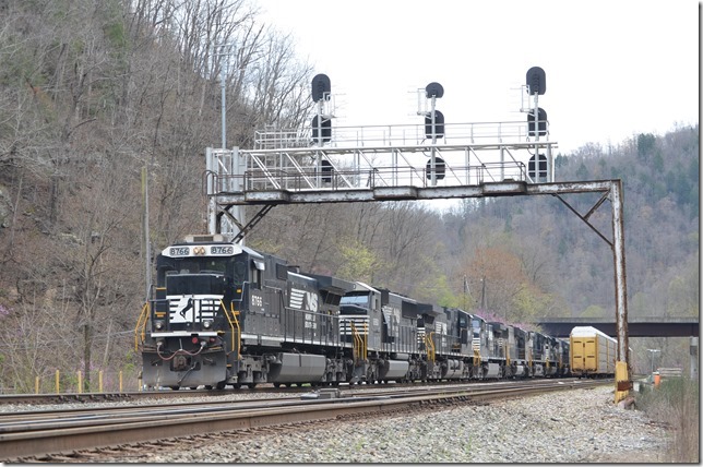 NS 8766-6950-9056-9310-6933-9667-1170-6911 roll time freight 17M-09 west at Hull with 8 loads/70 mtys. Note the old signal bridge is still standing although stripped of its signals. Those empty multi-levels are stored on the middle track. Hull.