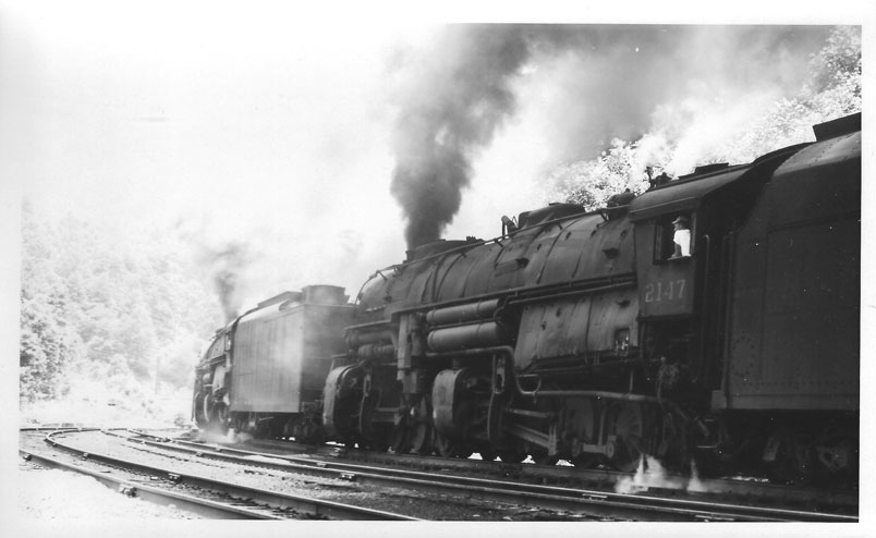 The head end is in Raitt Tunnel. The engineer is in his T-shirt, as it is very hot in the cab. They will cut off on the downhill slope and let the caboose couple to the train.