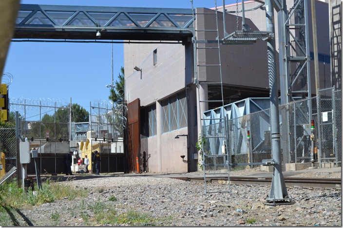 Closing the gate back. The brown steel gate is no longer used, because it was too difficult to move. In the early days the depot straddled the border here. Then it was decided to put an unoccupied strip between the two countries, so houses and businesses were demolished or moved and the depots separated. UP border gate Nogales AZ.