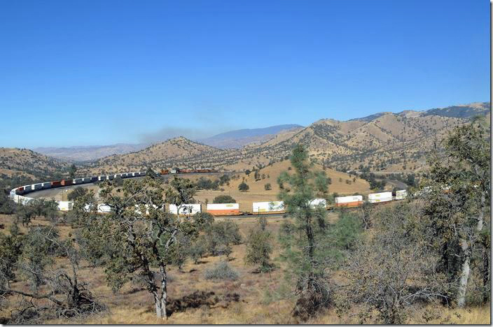 Notice the smoke beyond the distant hill behind the units. Cal Fire bombed the brush fire with Grumman Trackers and a 4-engine jet all day. BNSF 5489. View 2. Walong.